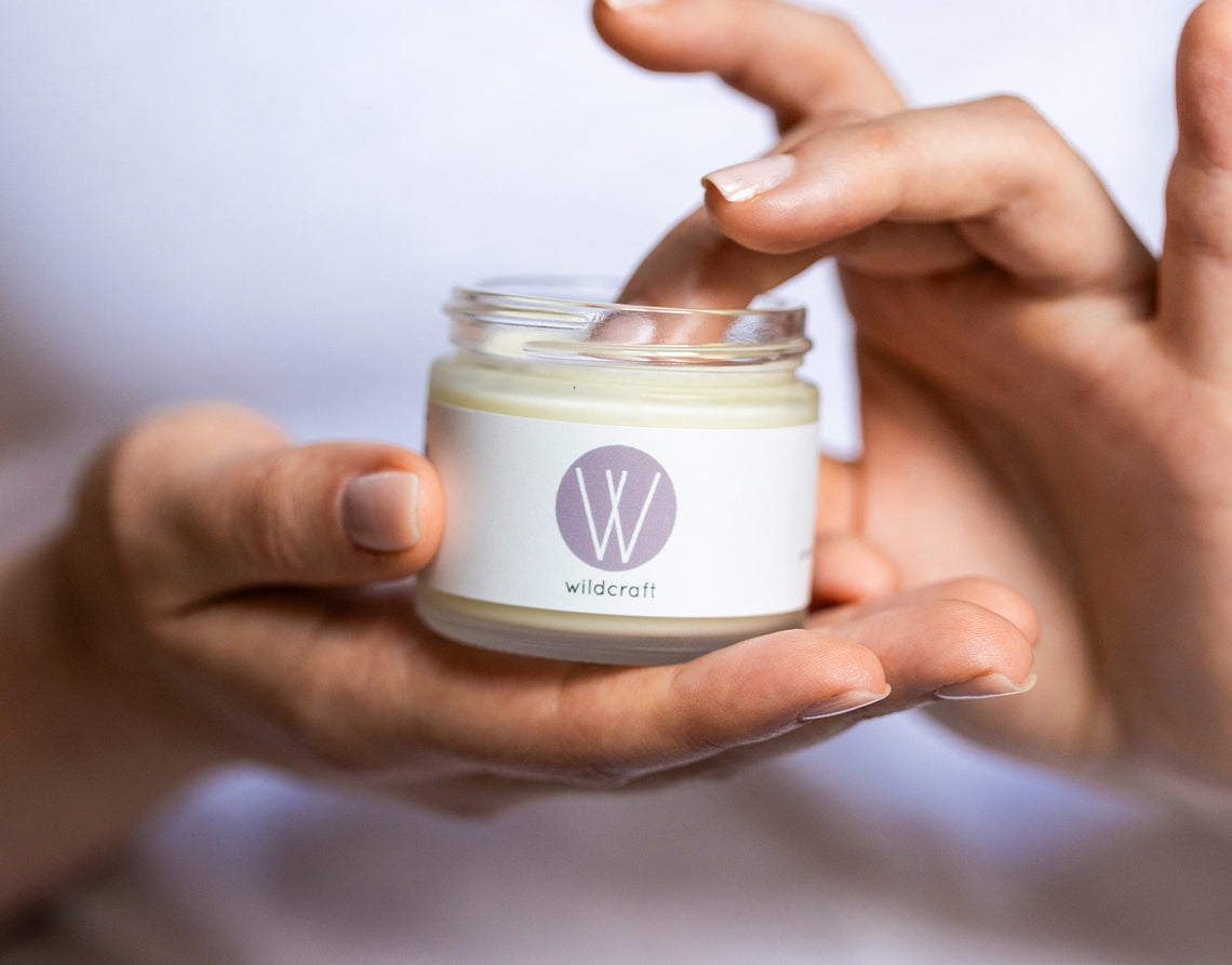 Hands holding an open jar of Clarify Face Cream