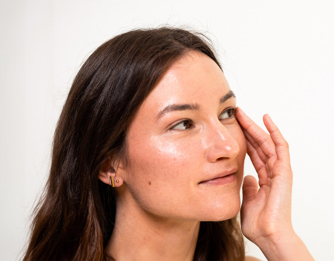 Woman applying face cream to her face.